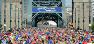 crowd of runners crossing bridge